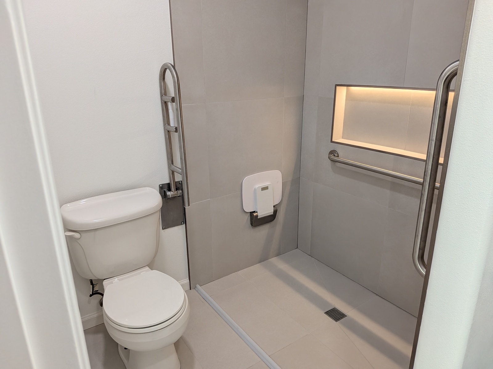 Accessible roll-in shower with grab bars at Edmonds Villa adult family home bathroom