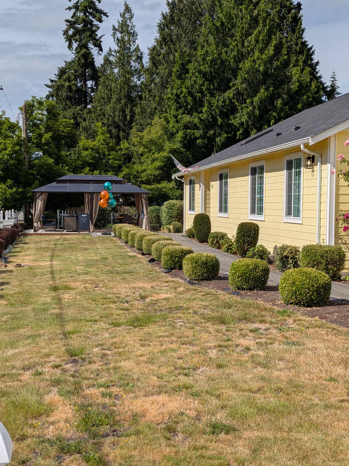Backyard gazebo with landscaped lawn at Edmonds Villa — outdoor space for residents and family visits