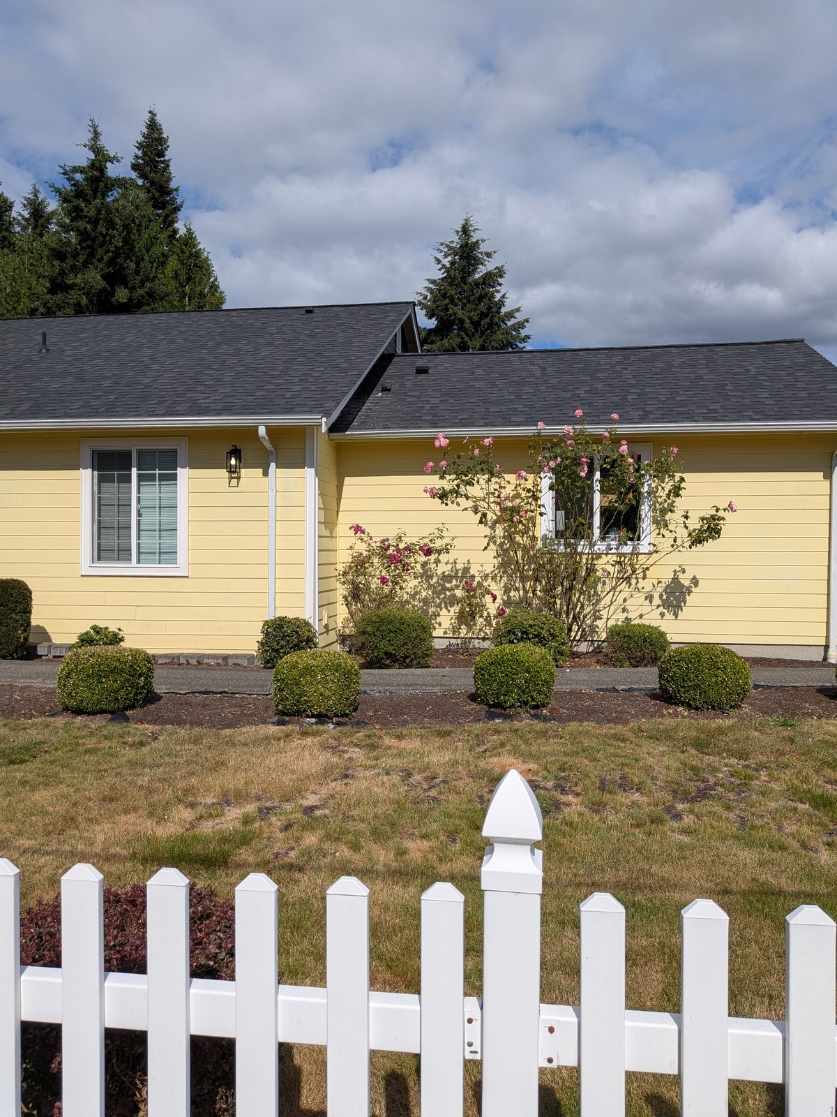 Edmonds Villa adult family home — a yellow house with white picket fence in a quiet Edmonds residential neighborhood, licensed for high-acuity senior care