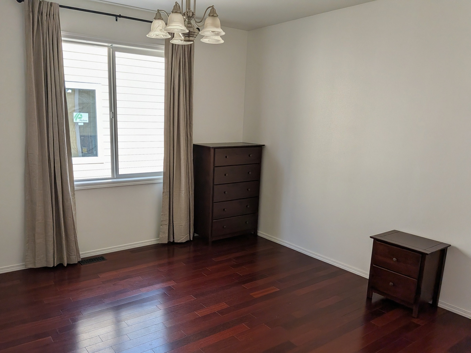 Private room with hardwood floors and built-in dresser storage at Edmonds Villa care home