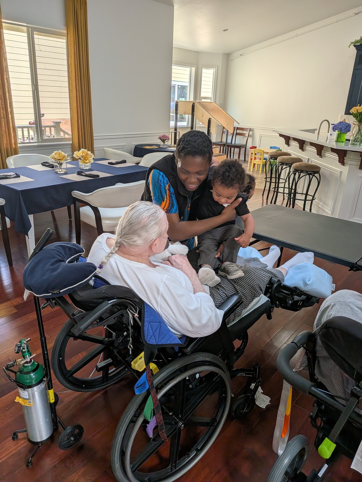 Intergenerational visit between elderly resident and young child at Edmonds Villa adult family home